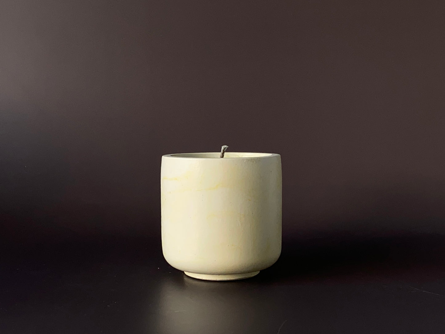 Hand-poured soy-wax candle in a handmade concrete jar for minimalist home decor