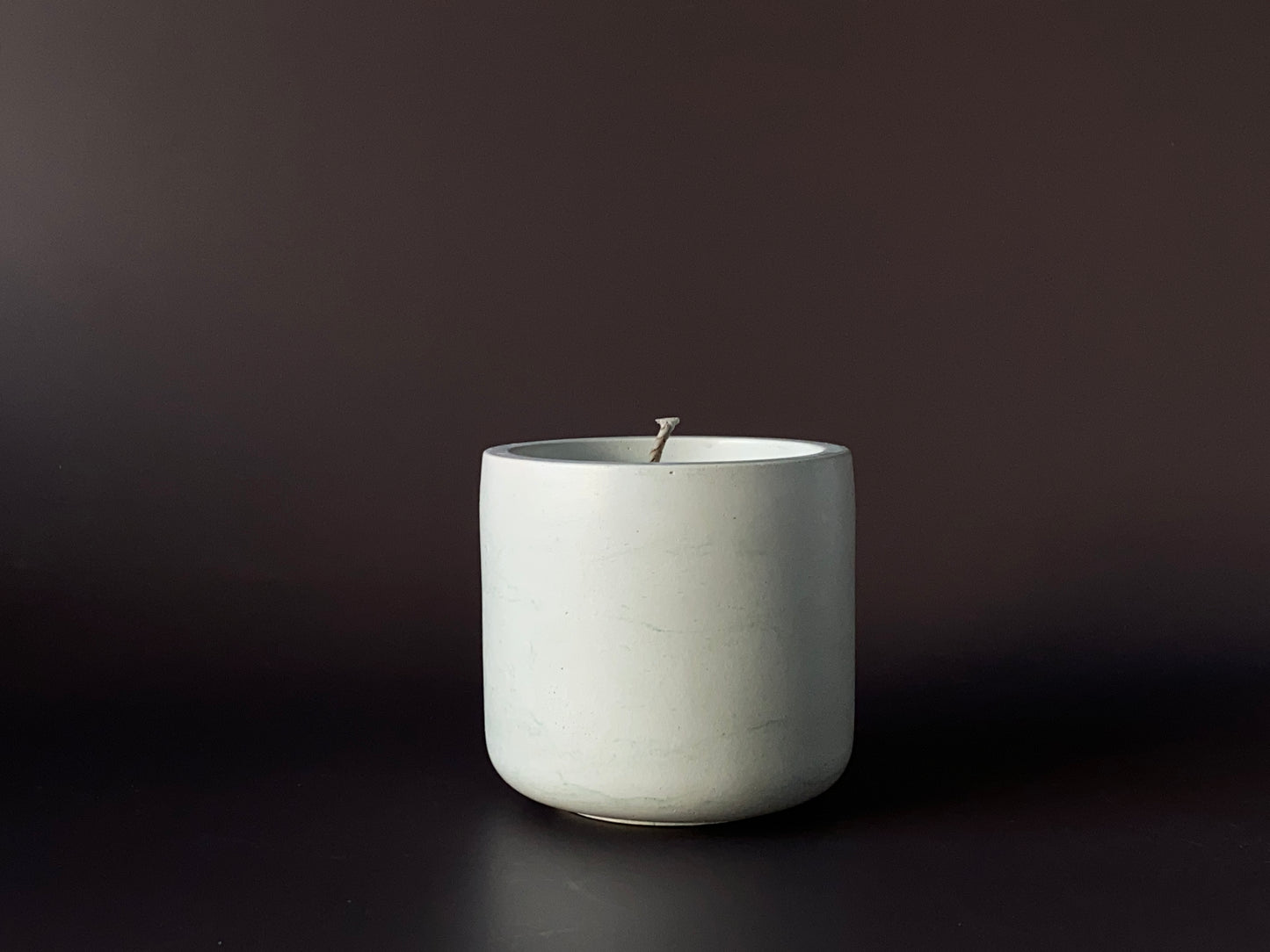 Hand-poured soy-wax candle in a handmade concrete jar for minimalist home decor